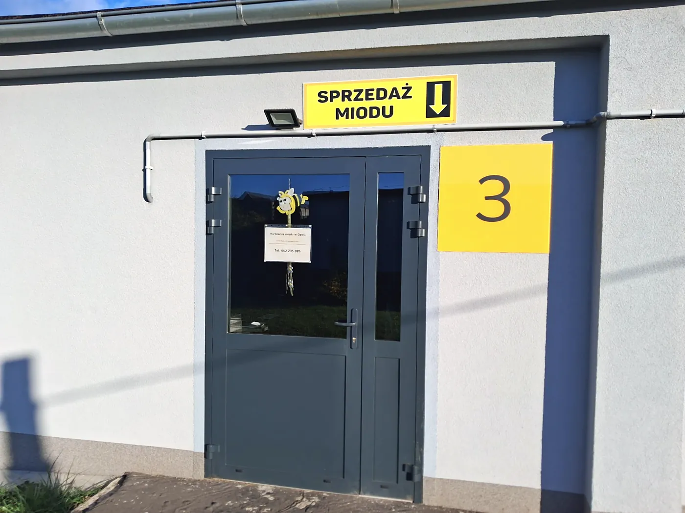 Wejście do hurtowni miodu Medowia – drzwi z tablicą SPRZEDAŻ MIODU i numerem 3